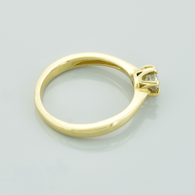 Złoty pierścionek z białym brylantem.