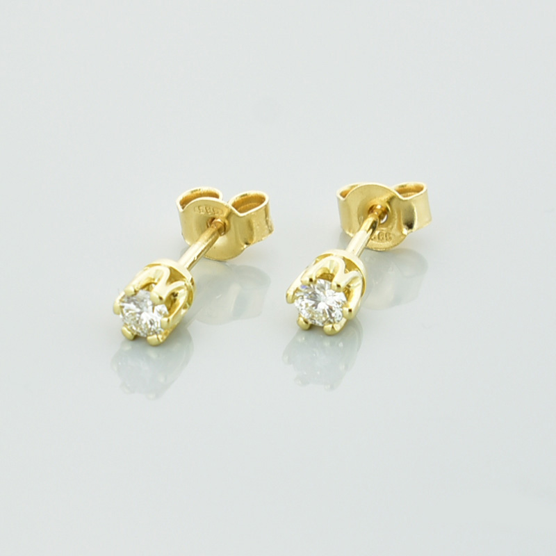 Złote kolczyki z białymi diamentami lub cyrkoniamii, zapinane na sztyft.