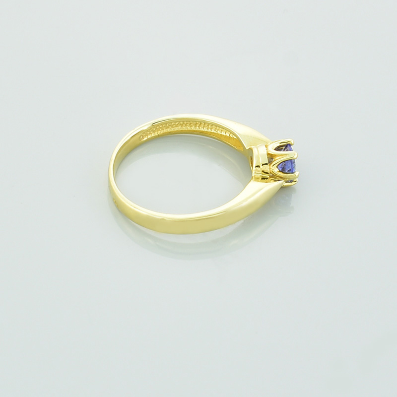 Złoty pierścionek z tanzanitem o niebiesko fioletowej barwie.