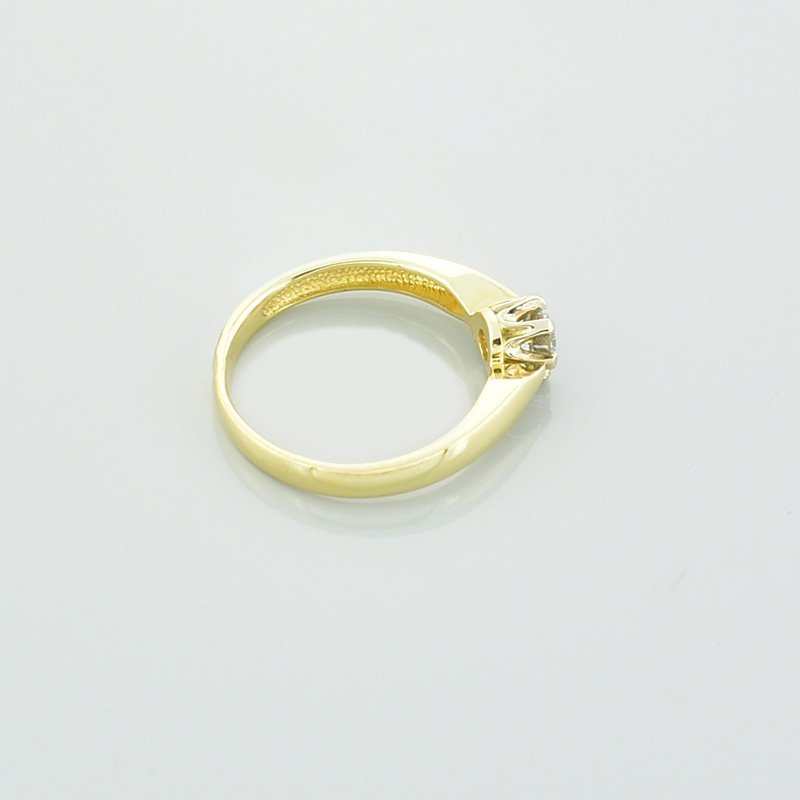 Złoty pierścionek zaręczynowy z diamentem lub cyrkonią.