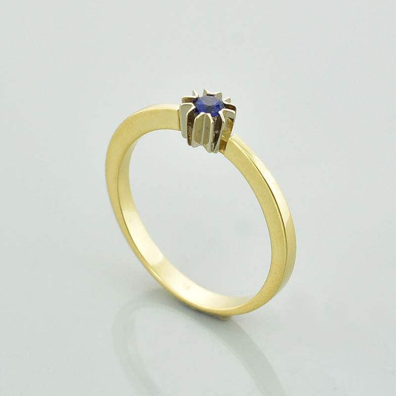 Złoty pierścionek z szafirem w nowoczesnej oprawie z białego złota.