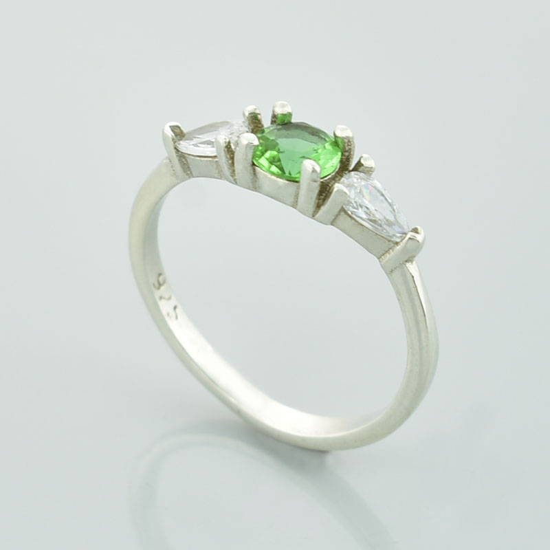 Srebrny pierścionek z zielonym okrągłym sułtanitem i dwoma cyrkoniami w kształcie łezki po bokach.