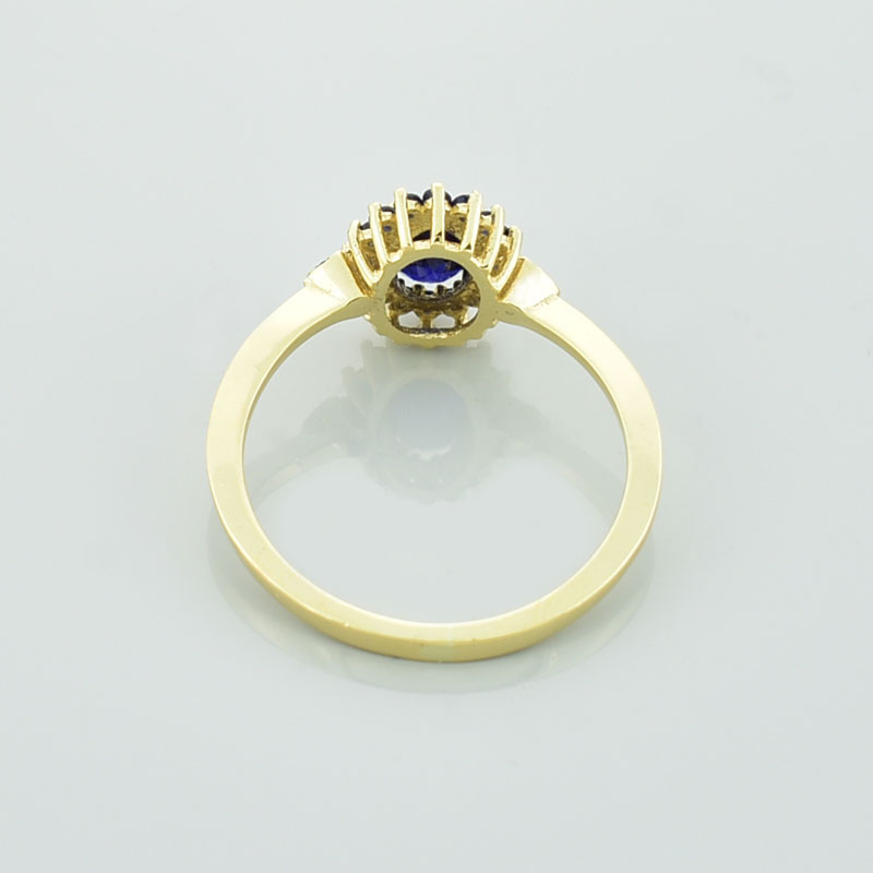 Złoty pierścionek z szafirami pokazany od tyłu.