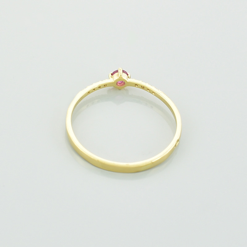 Złoty pierścionek z turmalinem i brylantami. Różowy turmalin i brylanty. Leżący tyłem.
