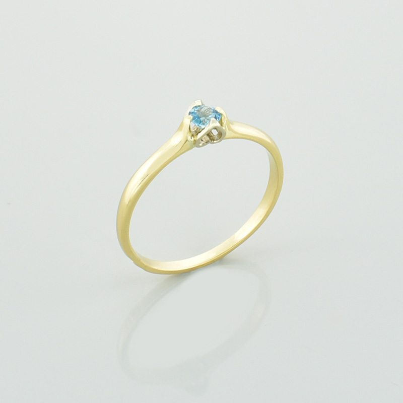 Złoty pierścionek serce z topazem w kolorze błękitnym.