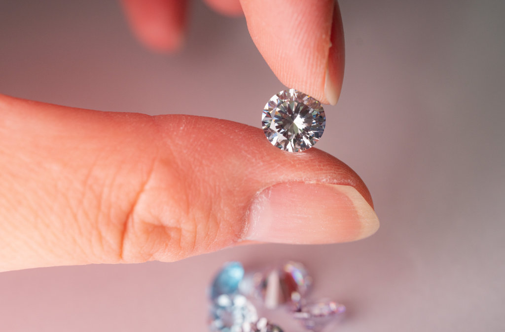 Moissanite vs diament - palce trzymające przykładowy kamień. 