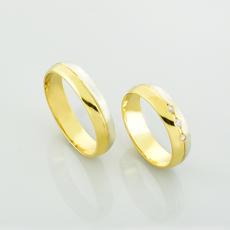 Obrączki z brylantami - półokrągłe, dwukolorowe z białego i żółtego złota stojące obok siebie.