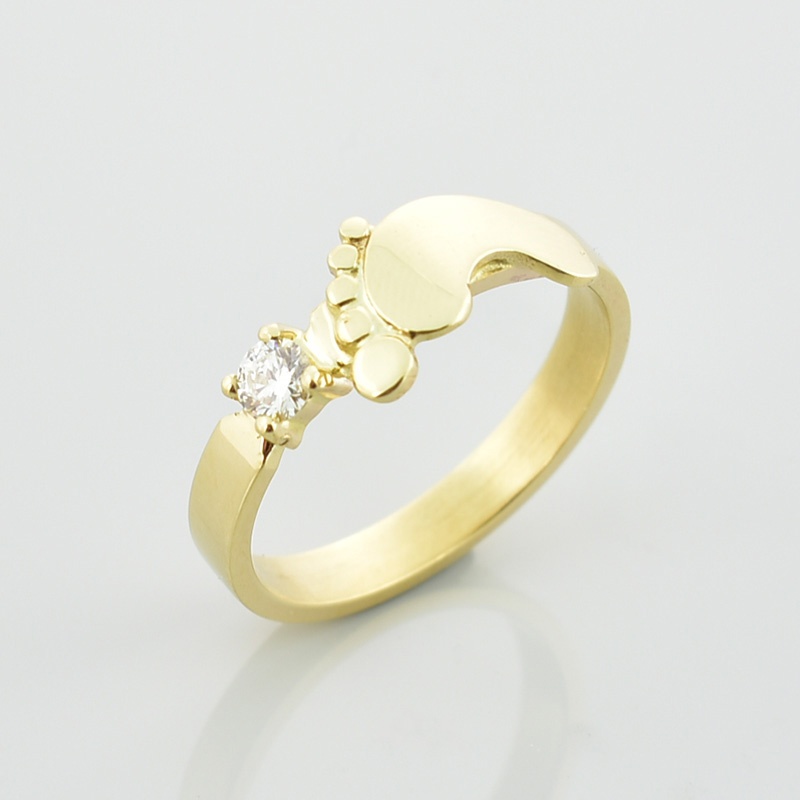 Ręcznie wykonany złoty pierścionek ze stópką i diamentem.