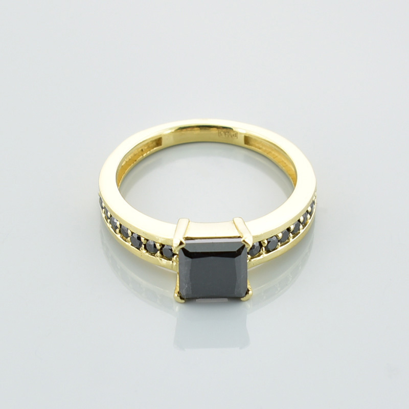 Złoty pierścionek z czarnymi diamentami.