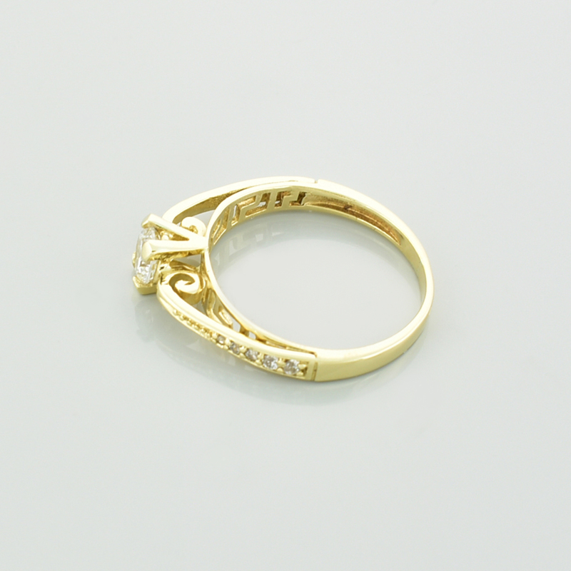 Złoty pierścionek z cyrkoniami pokazany od boku.