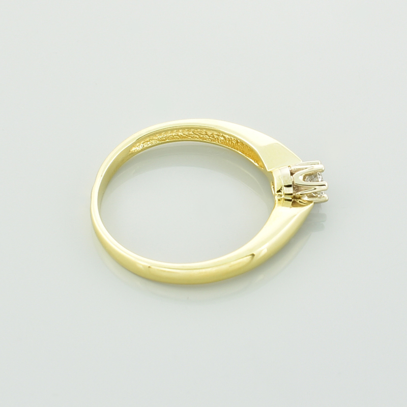 złoty pierścionek z brylantem pokazany od boku.