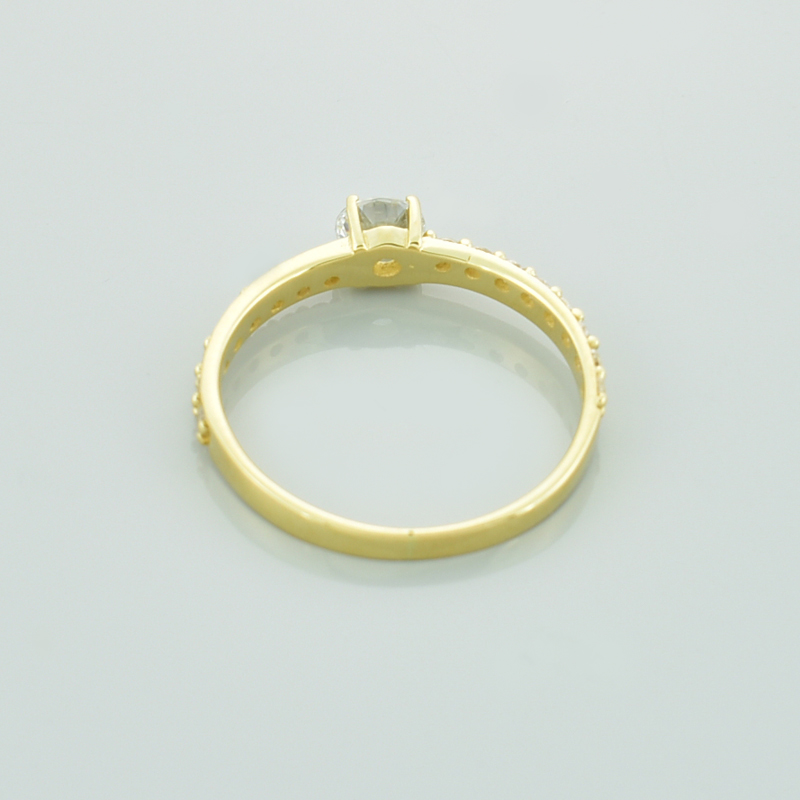 Złoty pierścionek z cyrkoniami pokazany od tyłu.