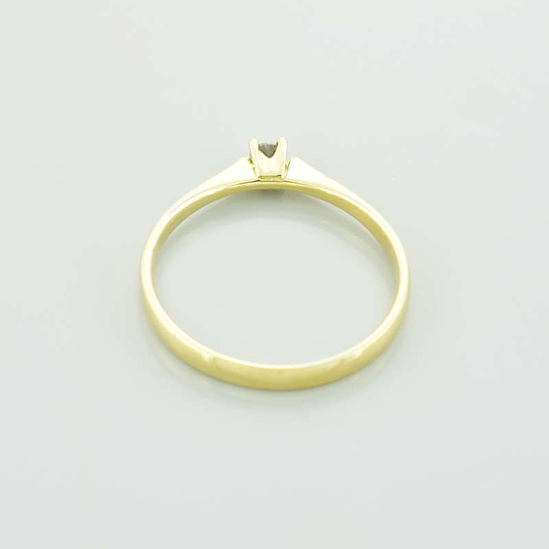 Złoty pierścionek z moissanitem leżący tyłem.