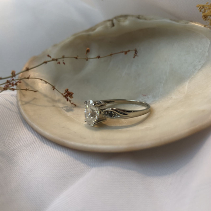 Pierścionek z białego złota z moissanitem i czarnymi diamentami widoczny od boku.
