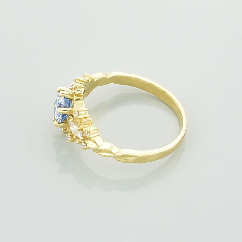 Złoty pierścionek z moissanitami pokazany od boku.