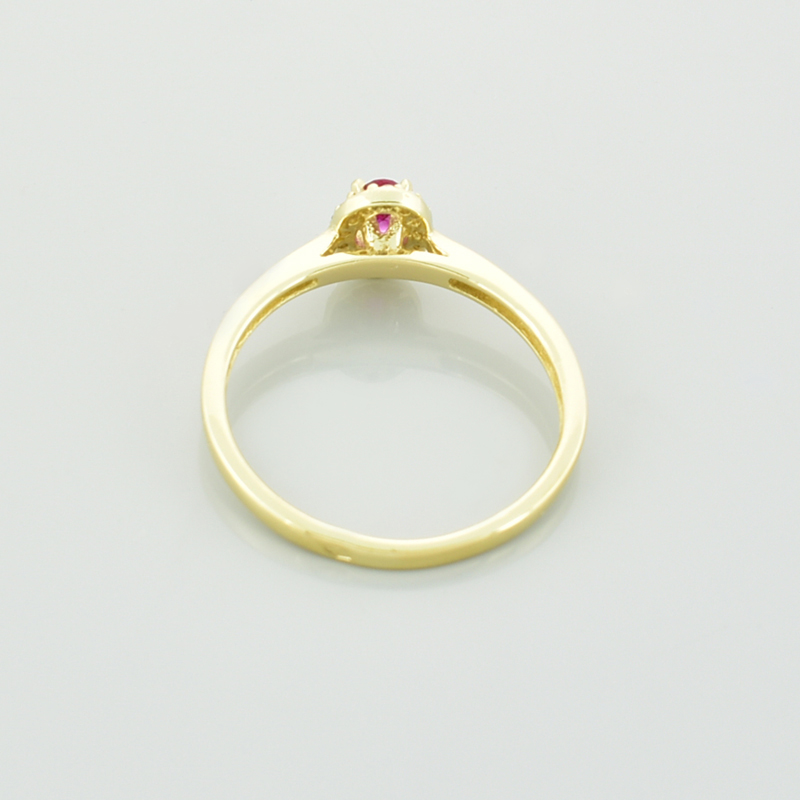 Złoty pierścionek z owalnym rubinem i cyrkoniami pokazany od tyłu.