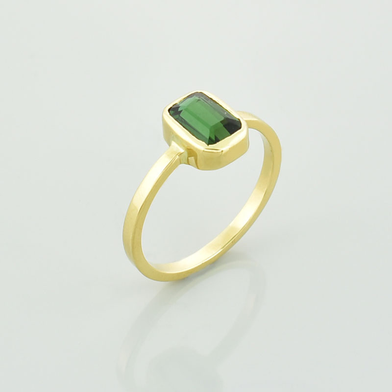 Złoty pierścionek z zielonym turmalinem w szlifie szmaragdowym.